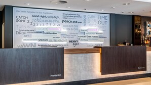 A hotel reception area with a large wall displaying various phrases and words related to sleep and relaxation.