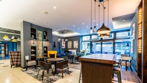 Un interior moderno con una zona de bar, asientos y vistas amplias a través de grandes ventanales.
