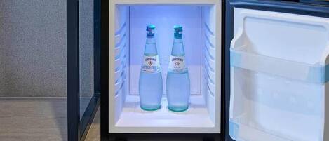 Un mini-réfrigérateur contenant deux bouteilles d’eau minérale Gerolsteiner Naturel.