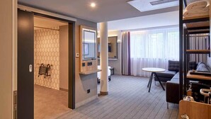 A modern hotel room with a large bed, a desk, a chair, a TV, and a window with curtains. - Premier Inn Lindau (Lindau)
