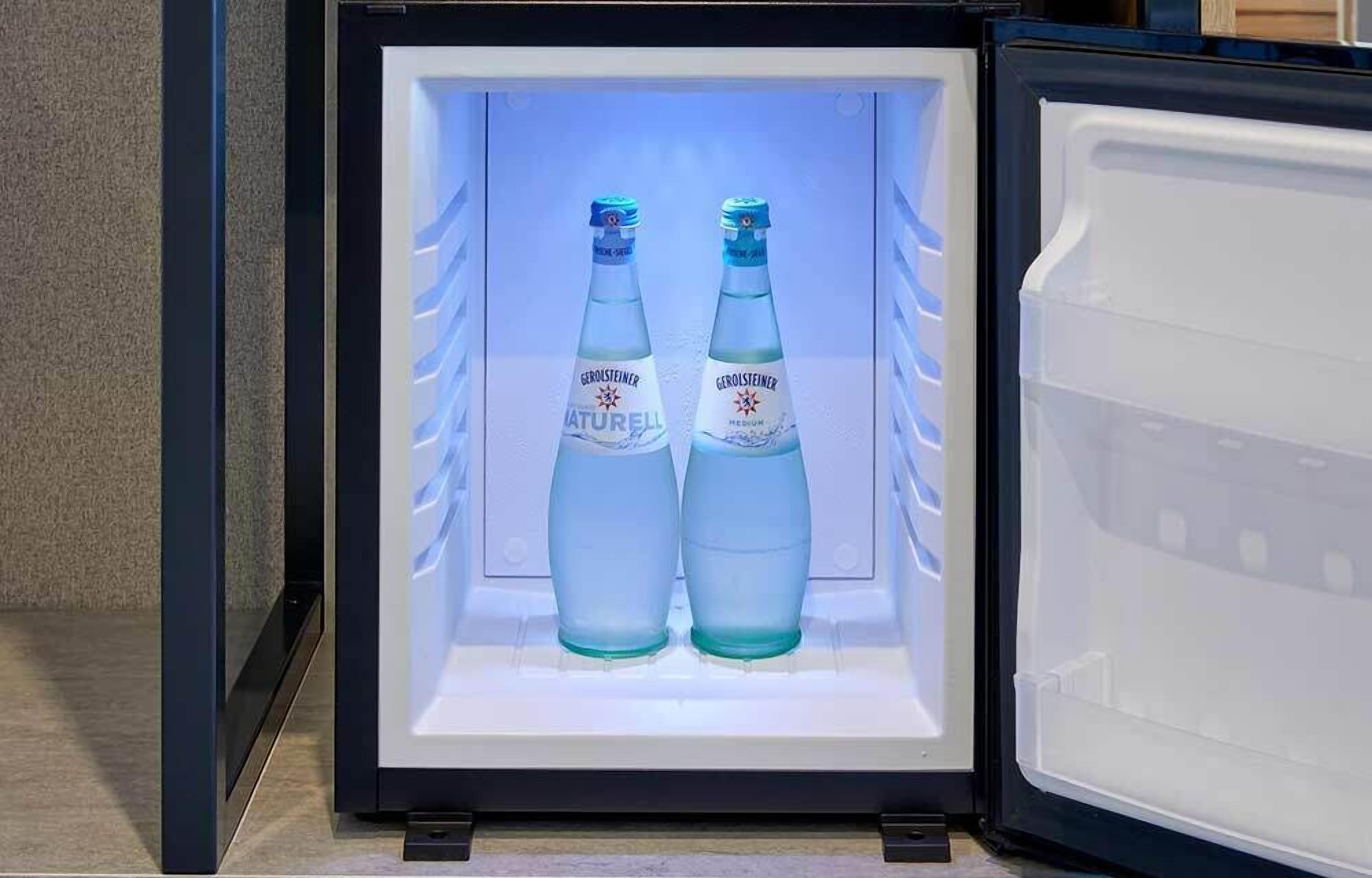 A refrigerator with two bottles of Gerolsteiner Naturella medium water.
