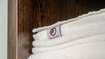 Una pila de toallas blancas con el logotipo de 'Premier Inn'.