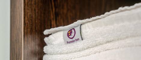 A stack of white towels with a 'Premier Inn' logo.
