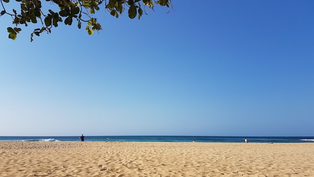 A beach with a clear sky, a sandy shore, and a few people in the distance. - Casa Vista Mar 1 (Rio San Juan)