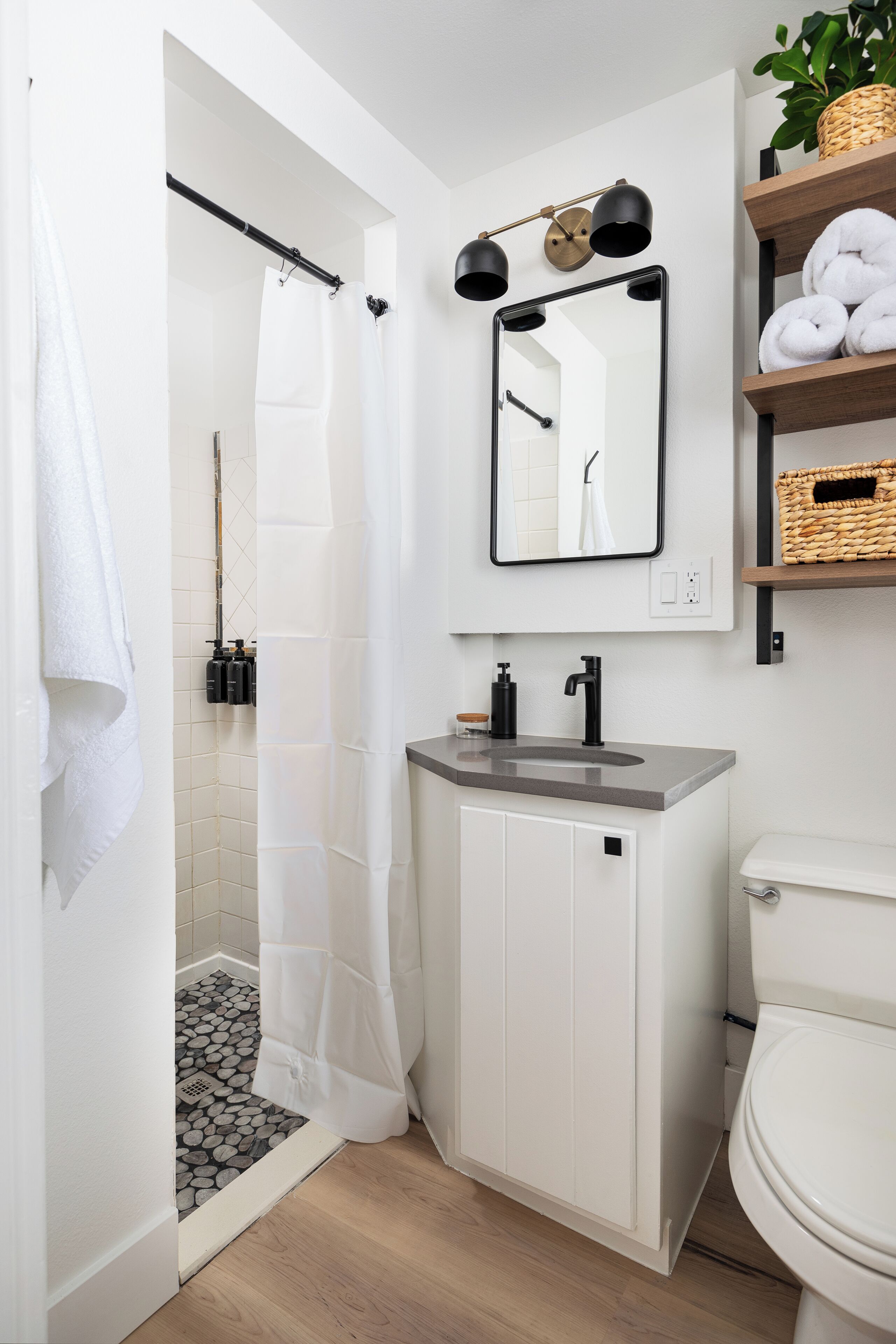 A modern bathroom with a shower, toilet, and sink.