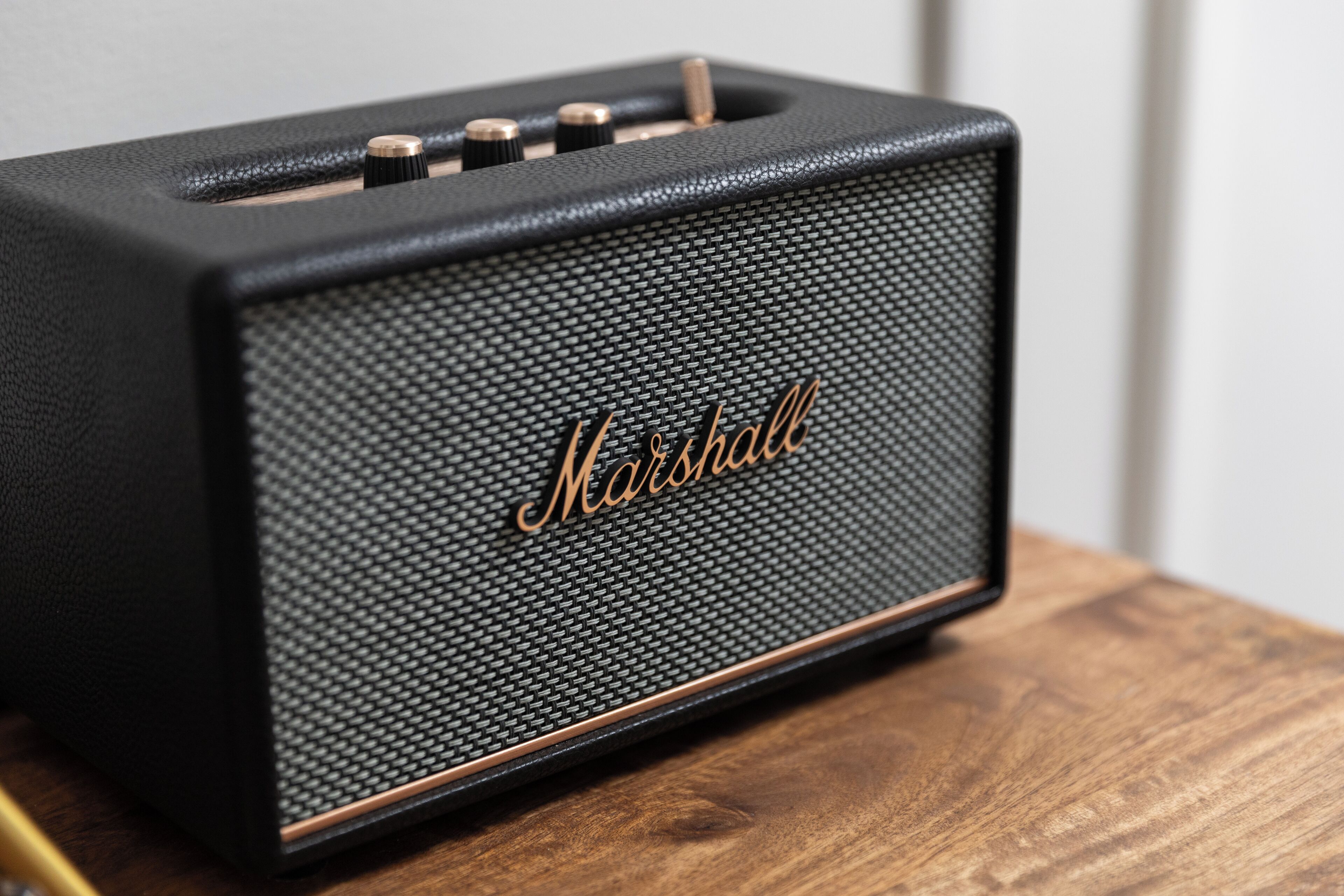 Un amplificatore Marshall nero su un piano di legno.
