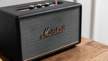 Un amplificatore Marshall nero su un piano di legno.