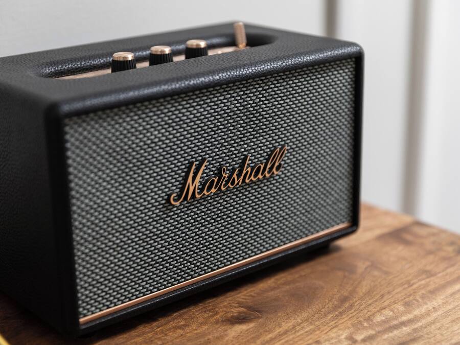 Un amplificatore Marshall nero su un piano di legno.