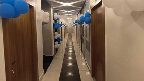 Un corridoio con pavimento in marmo nero, pareti bianche e soffitto con illuminazione a incasso.