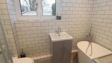 Separate bathtub and shower, deep-soaking bathtub, towels