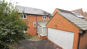 A residential property with a brick house, a garage, and a conservatory. - St Albans Spacious Party House (St Albans)