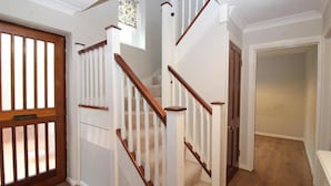 A staircase with white railings and wooden handrails, leading to a carpeted landing. - St Albans Spacious Party House (St Albans)