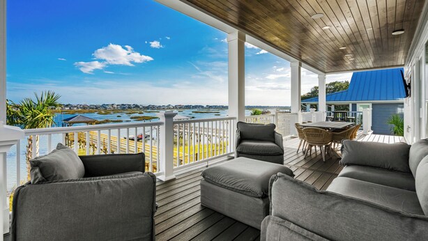 A covered outdoor area with a view of the water and distant buildings. - Tyson’s Corner: Luxe Marshfront Retreat w/ Pool (Murrells Inlet)