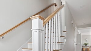 A staircase with white railings and wooden steps leading to an upper floor. - Portside Overlook: Downtown Rockport Penthouse with stunning views (Rockport)