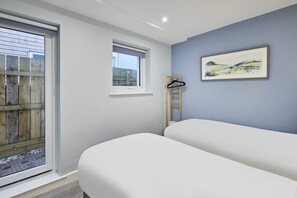 A bedroom with a large window, a small window, and a painting on the wall. - Host & Stay | Harrow Bothy (Tweedmouth)