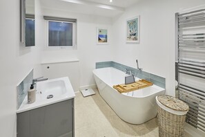 A modern bathroom with a freestanding bathtub, a sink, and a window. - Host & Stay | Harrow Bothy (Tweedmouth)