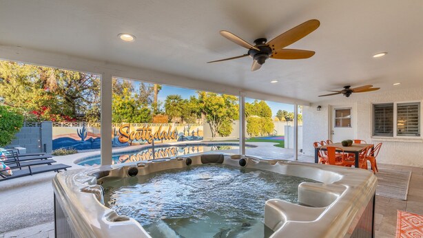 Un jacuzzi con vistas a un jardín ajardinado y una piscina.
