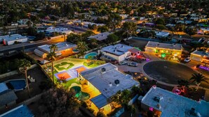 Vista aérea de una zona residencial con casas, una piscina y una cancha de tenis.