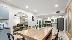 Una cocina moderna con zona de comedor, que incluye una mesa de madera, sillas y un sofá.