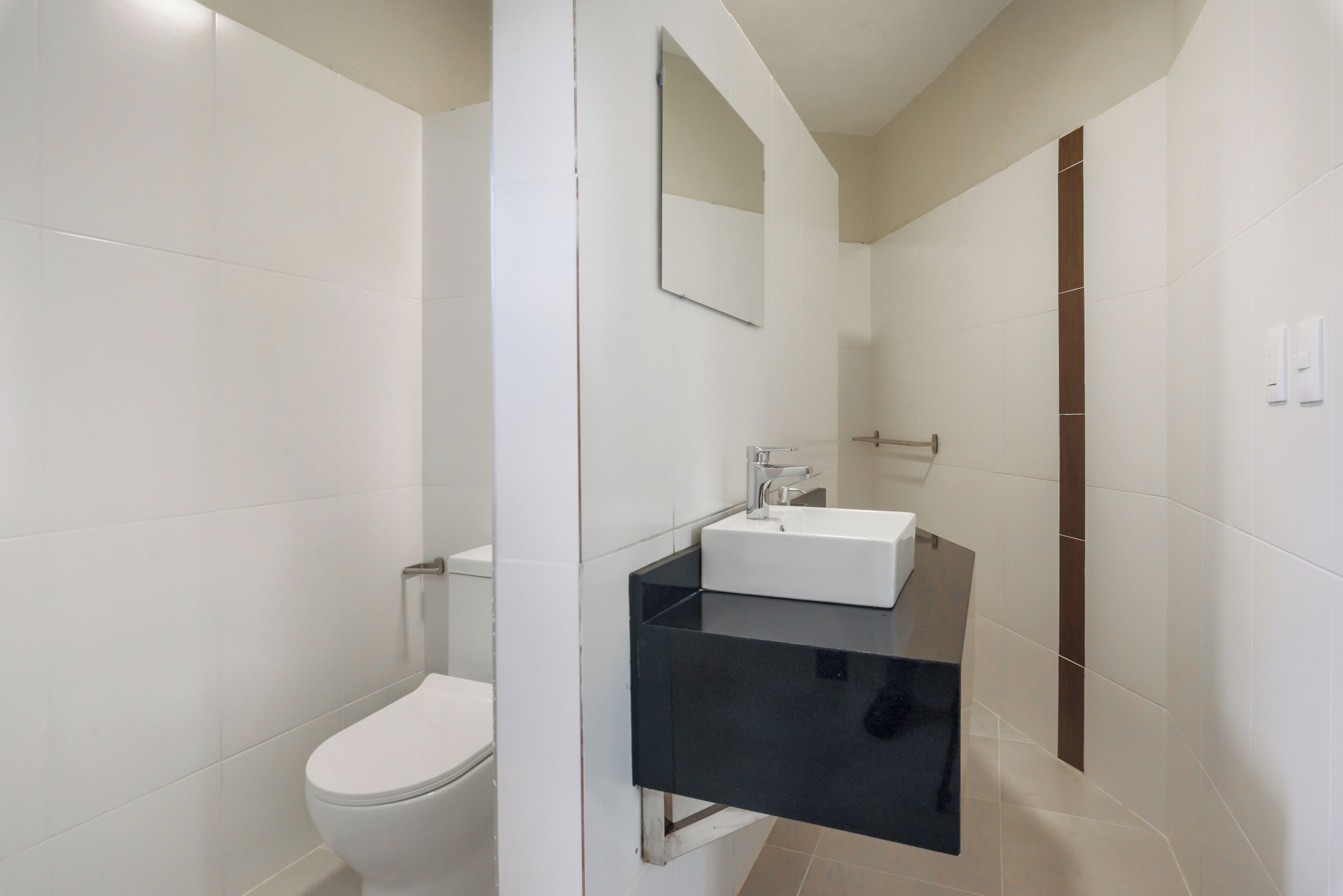Ein modernes Badezimmer mit Toilette, Waschbecken und Spiegel.