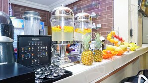 A coffee machine, two large dispensers with fruit, and a display of coffee pods.