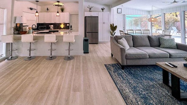 A modern living room with a grey sofa, a coffee table, and a blue rug. - Private Pool Villa | 5 Min to Disney & Universal (Orlando)