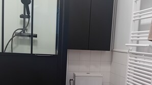 A modern bathroom with a shower, toilet, and a sink area.