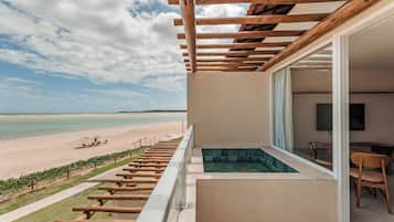 A balcony with a view of a beach and a pool.