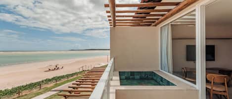 A balcony with a view of a beach and a pool.