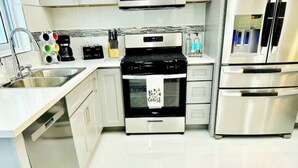 A modern kitchen with a built-in oven, stainless steel appliances, and a coffee maker. - Private pool island retreat.

 (Nassau)