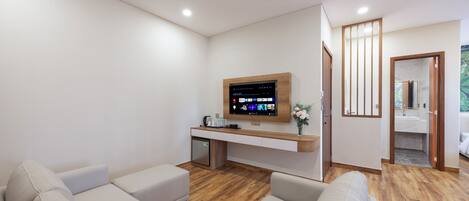 Una sala de estar moderna con un televisor de pantalla plana, un mueble de madera y un sofá.