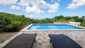 A rectangular swimming pool with a clear blue sky and clouds above. - Casa Vista Mar 3 (Rio San Juan)