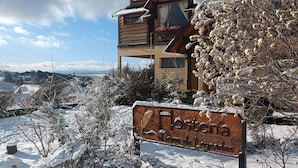 A wooden lodge with a sign reading "HosterÃa Terra de Leyendas."
