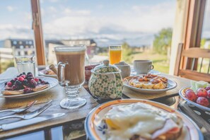 Une table de petit-déjeuner avec différents plats, une carafe et des verres.