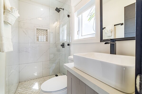 A modern bathroom with a shower, toilet, and vanity. - Coral Reef Casa & Mistico Beach Club+Boat Shuttle (San Pedro)