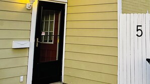 A yellow building with a black door, a white picket fence, and a number '5' on the fence. - Spacious 4 bedroom home walking distance from snowmobile and orv trails (Kincheloe)