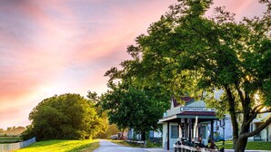 Un edificio histórico llamado 'Marthasville, MO' con un porche cubierto y un sendero de grava que conduce a él.