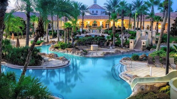 Ein Resort mit großem Pool, Palmen und einem Gebäude mit Kuppeldach.