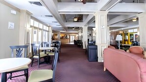 Eine geräumige Hotelhalle mit hohen Decken, verschiedenen Sitzbereichen und einer zentralen Rezeption.