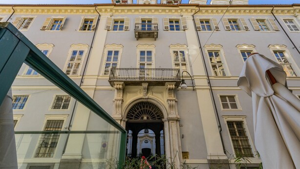 Un bâtiment historique doté d’une entrée centrale, de nombreuses fenêtres et de balcons.