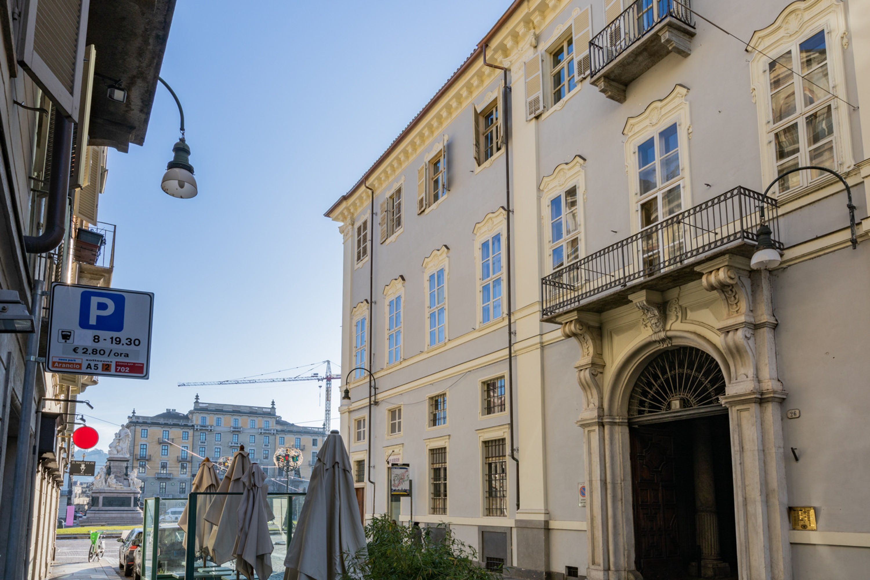 A building with a classical facade, a visible entrance, and a street sign indicating parking availability.