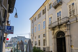 A building with a classical facade, a visible entrance, and a street sign indicating parking availability. - Appartamento a Palazzo Coardi by Wonderful Italy (Turin)