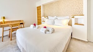 Quarto de hotel moderno com uma cama grande, uma escrivaninha de madeira e uma prateleira na parede.