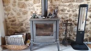 A stone wall, a wood-burning stove, a standing heater, and wicker baskets. - Old restored village house with terrace (Jouques)