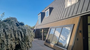 A modern building with a sloped roof, large windows, and a gravel driveway. - Nina's Hideaway Hotel - Madame's Dream (Saint-Girons)
