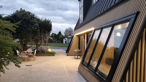 A modern building with large windows, a gravel driveway, and outdoor seating. - Nina's Hideaway Hotel - Madame's Dream (Saint-Girons)