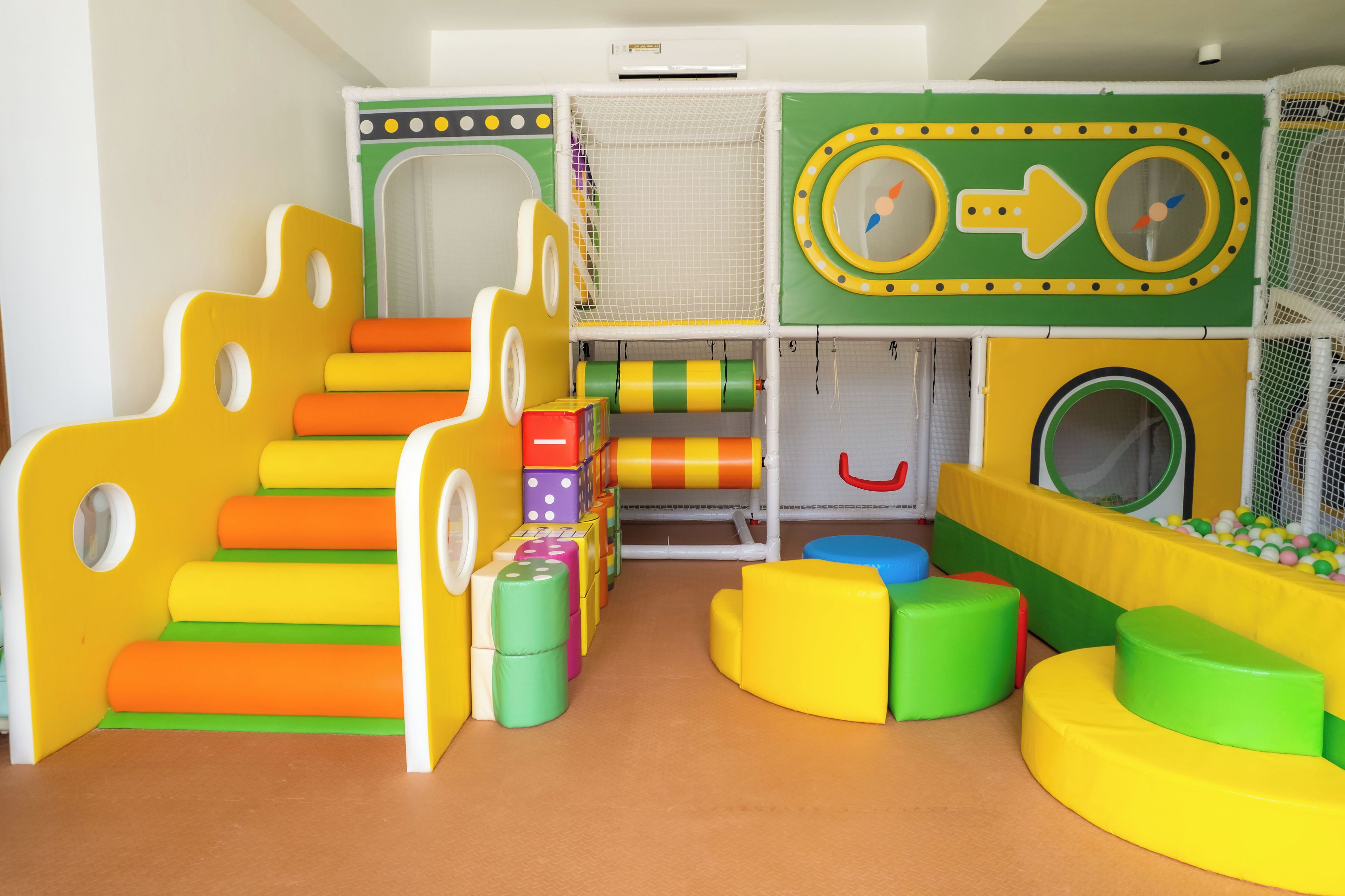 A children's play area with colorful steps, a ball pit, and a play structure.