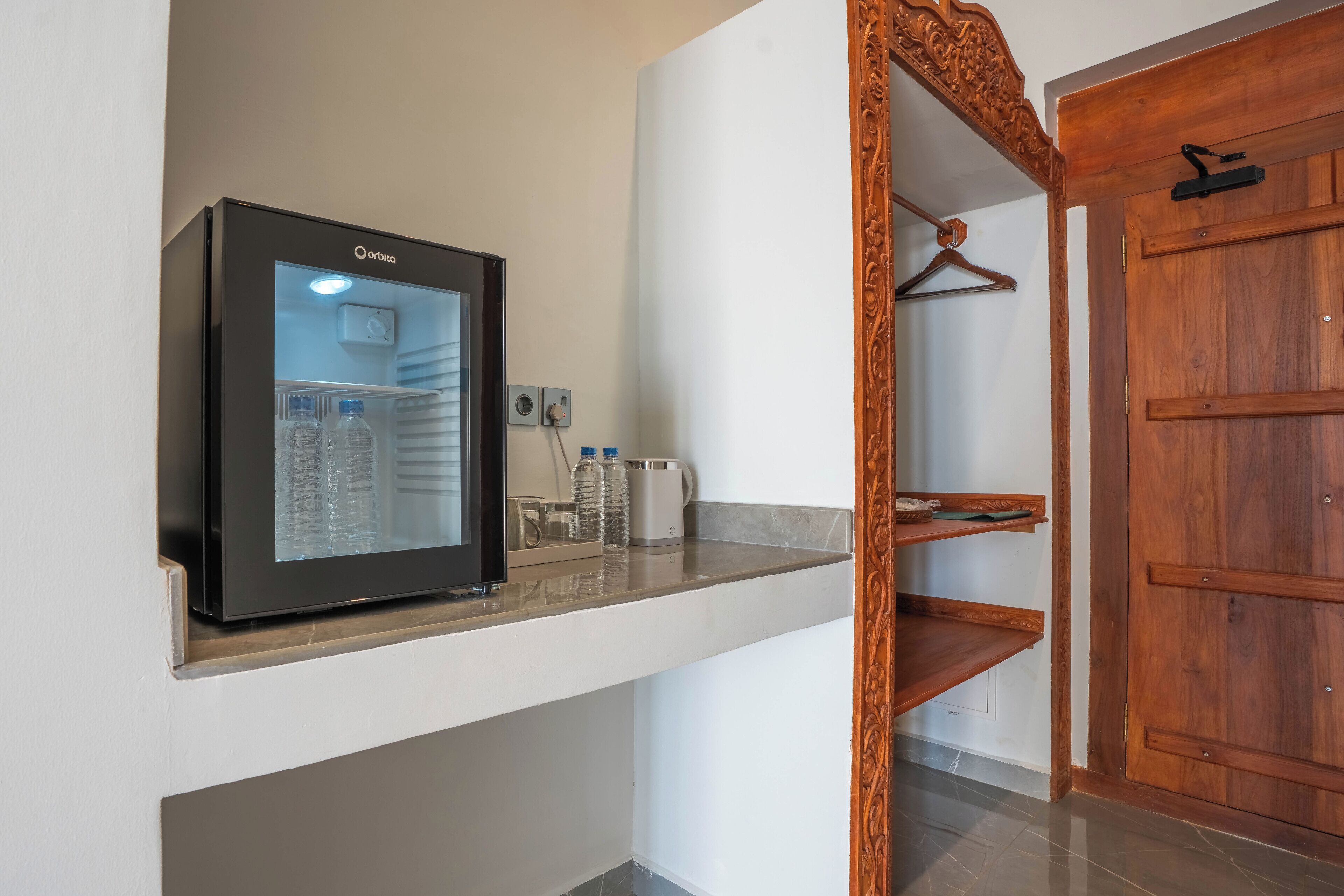 Een moderne keuken met een inbouwkoelkast, een koffieapparaat en een waterdispenser.