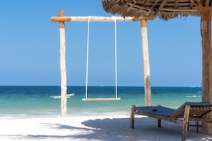 Am Strand, weißer Sandstrand, Liegestühle, Sonnenschirme