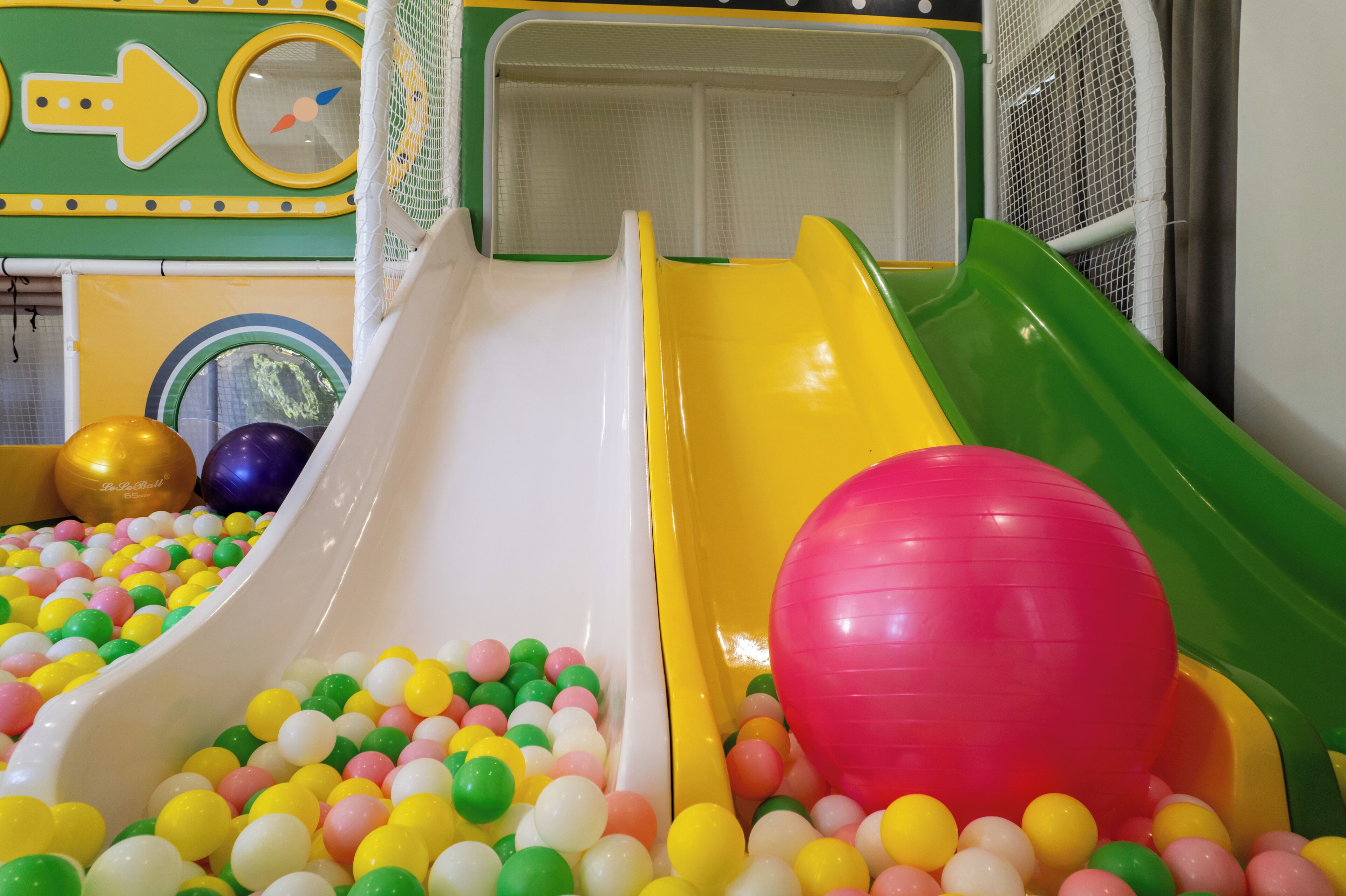 A children's play area with multiple slides and a ball pit filled with colorful balls.